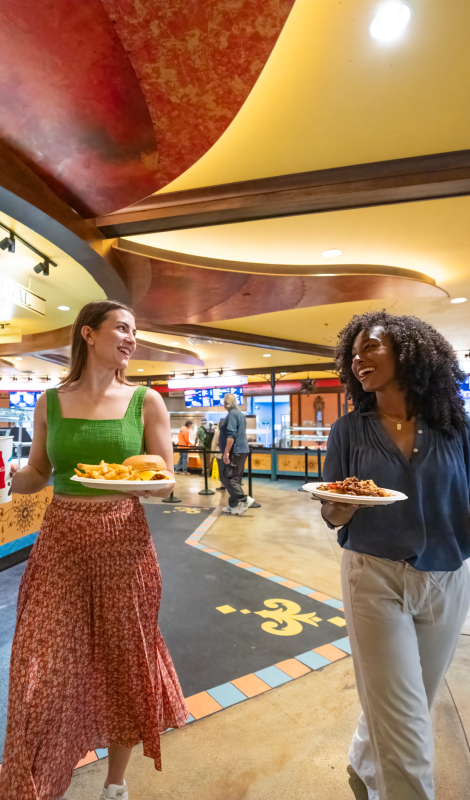 Two women holding food in Dragon Fire Grill at Busch Gardens Tampa Bay