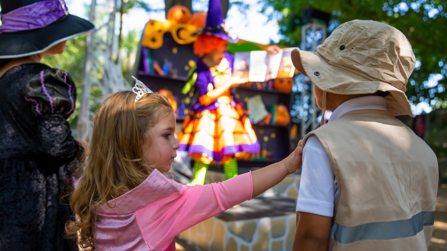 Kids in costume enjoying story time with Kandy the witch-in-training at Busch Gardens Tampa Bay Spooktacular.