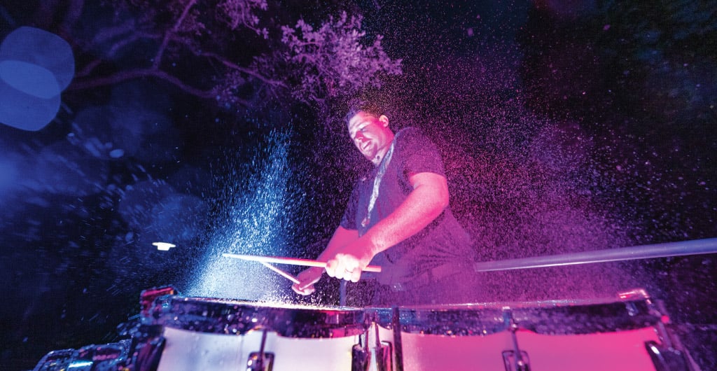 Percussionist playing drums with water splashing in the air