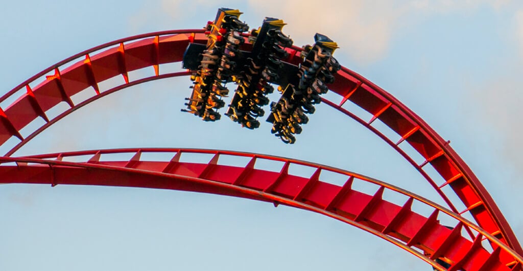 A group of people upside down as they ride through a loop on an intense red roller coaster called SheiKra at Busch Gardens Tampa Bay, located in Florida