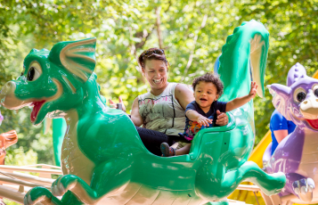 Adult and child on a children's dragon ride