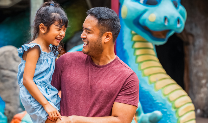 Father and daughter in front of dragon statue