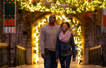A man and woman in front of Christmas lights