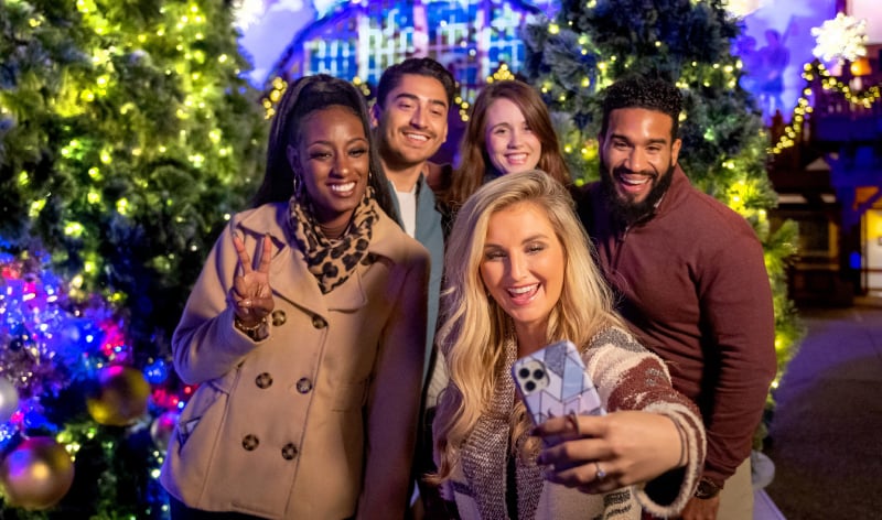 A group of friends taking a selfie in front of Das Festhaus during Christmas Town
