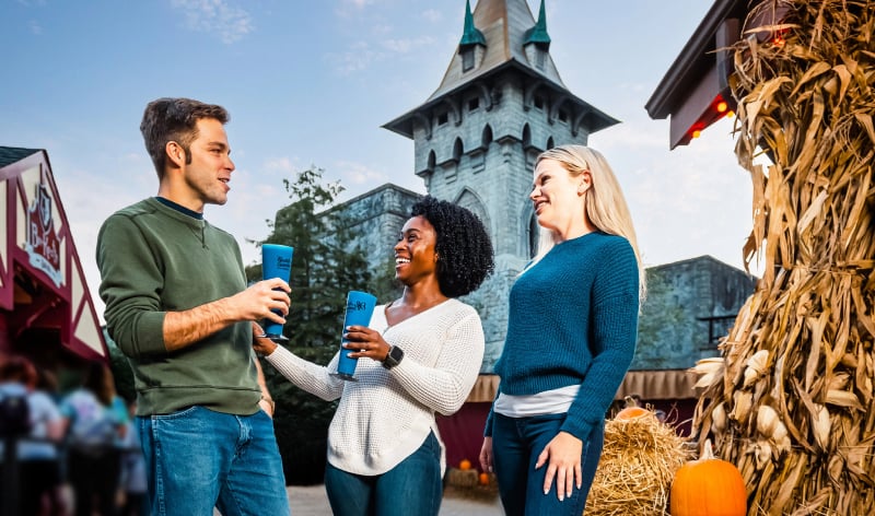 Three people in front of DarKoaster at Busch Gardens Williamsburg