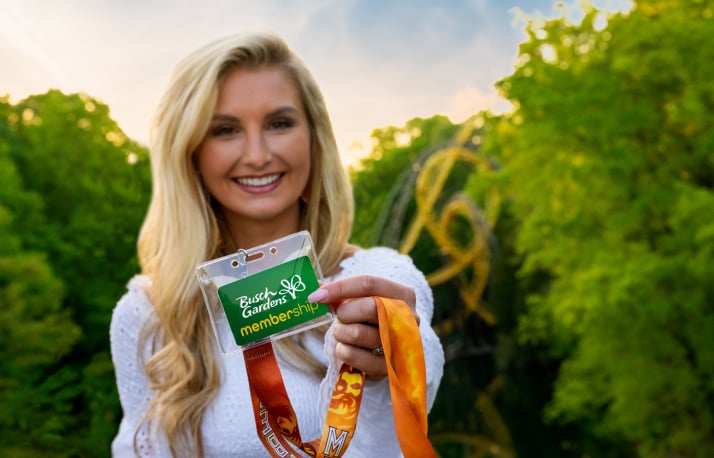 Woman holding a Busch Gardens Williamsburg Membership card