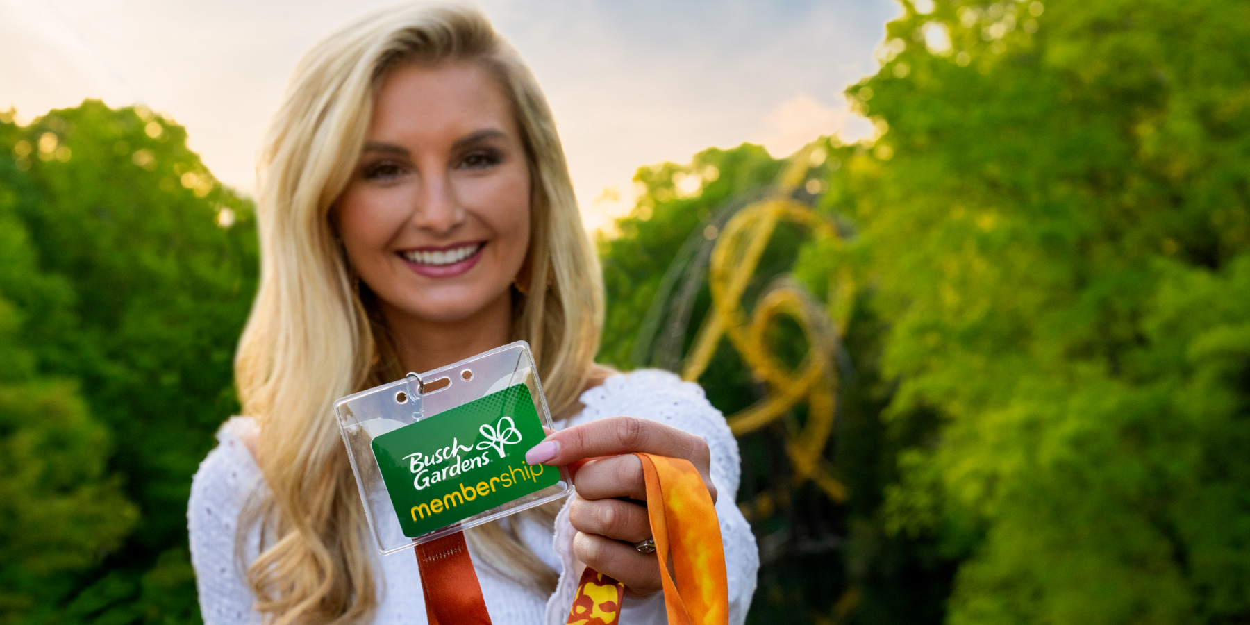 A woman holding up a Busch Gardens Williamsburg Membership Card