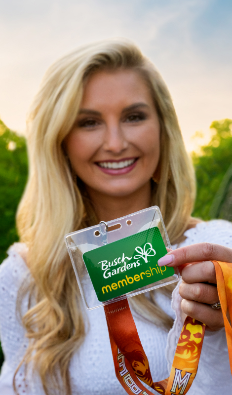 A woman holding up a Busch Gardens Williamsburg Membership Card