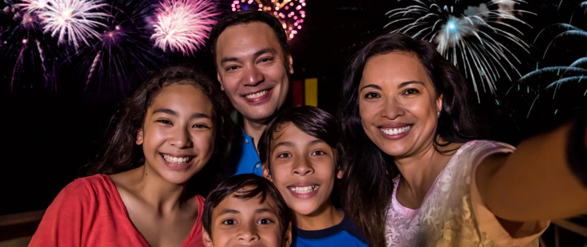 Family of four in front of fireworks