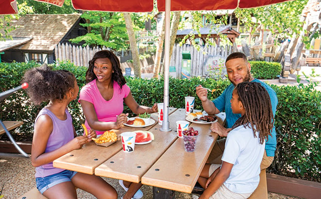 Family enjoying a meal on a picnic table