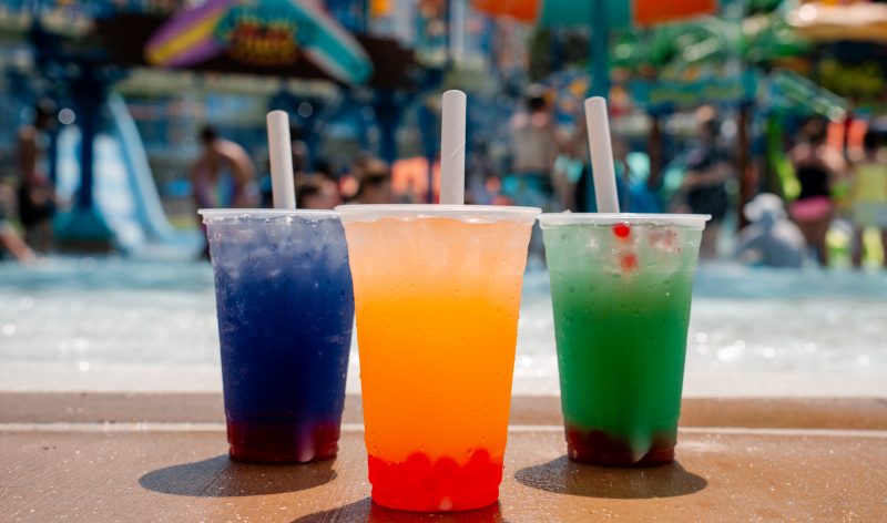 Three tropical drinks in front of a wave pool