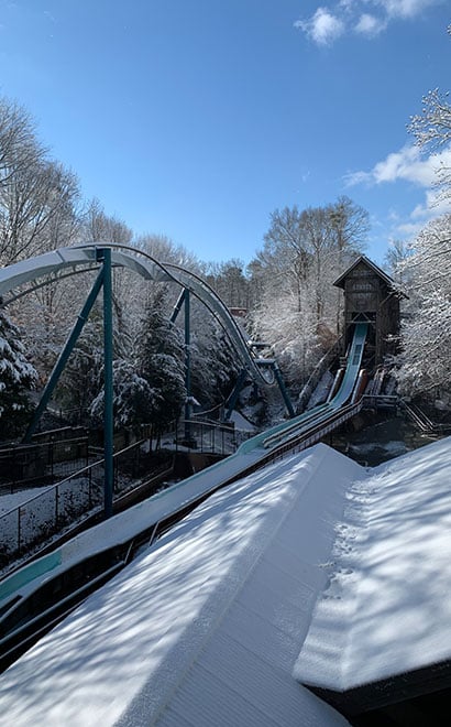 Snow day view of Verbolten roller coaster and Le Scoot log flume ride at Busch Gardens Williamsburg