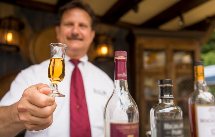 Busch Gardens Employee serving a small glass of liquor for a specialty tasting.